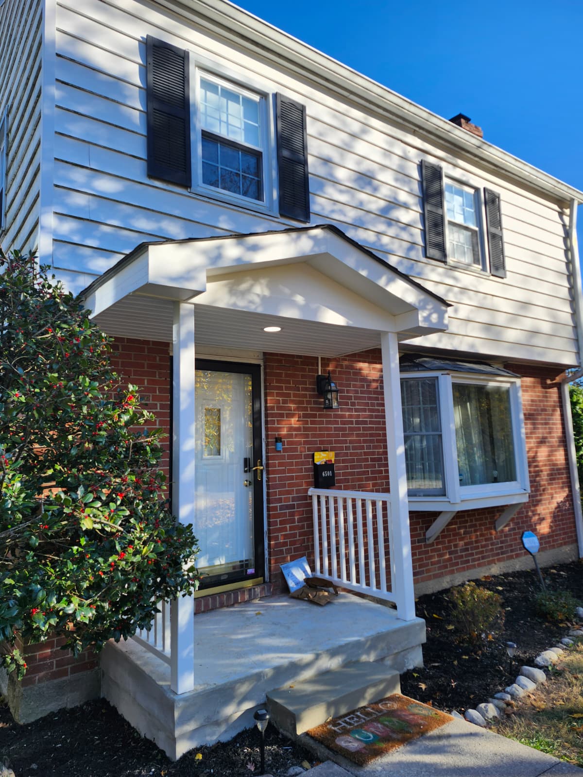 Front porch after renovation — new portico roof and railings