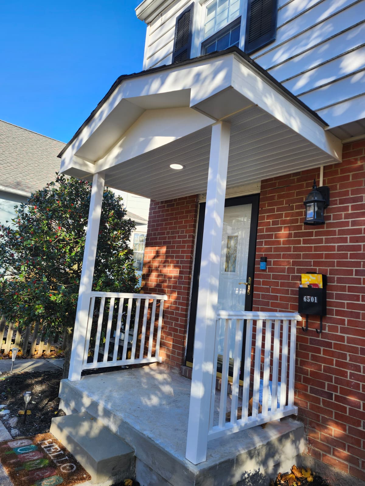 Front porch after renovation — new portico roof and railings