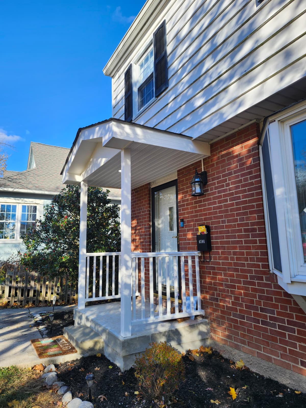 Front porch after renovation — new portico roof and railings