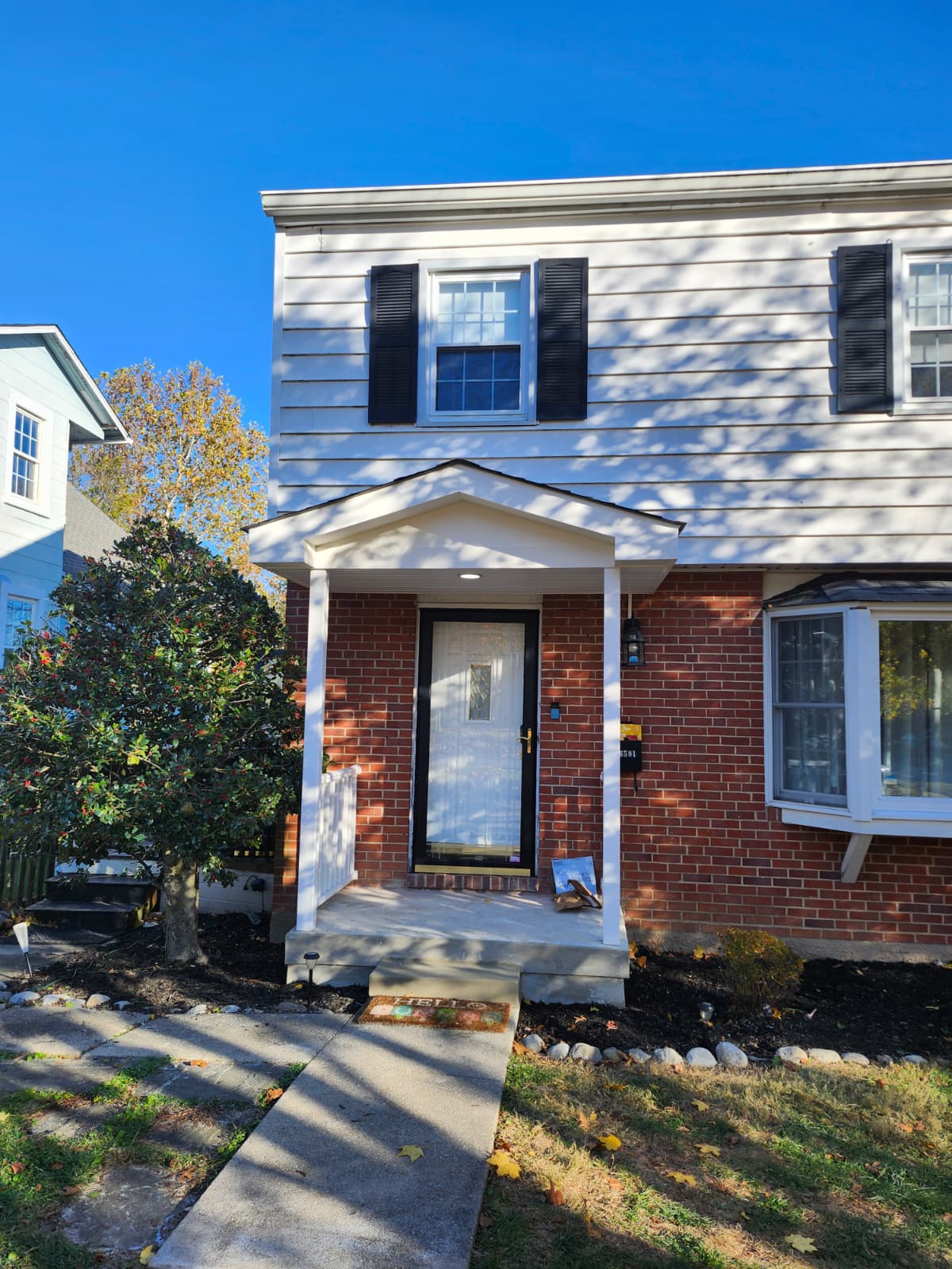 Front porch after renovation — new portico roof and railings