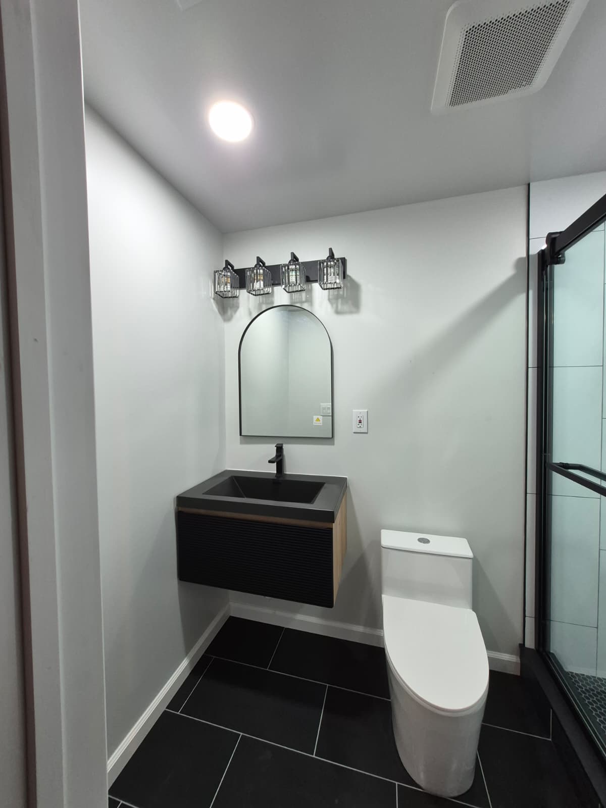 Basement bathroom after renovation — finished tile and fixtures