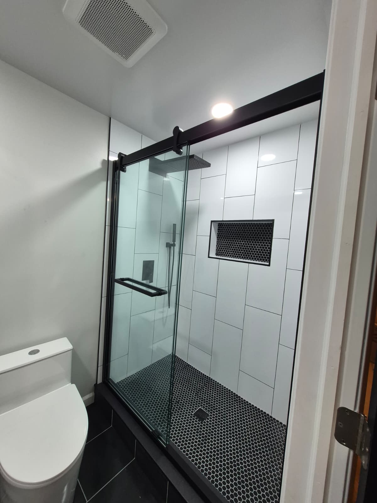 Basement bathroom after renovation — finished tile and fixtures