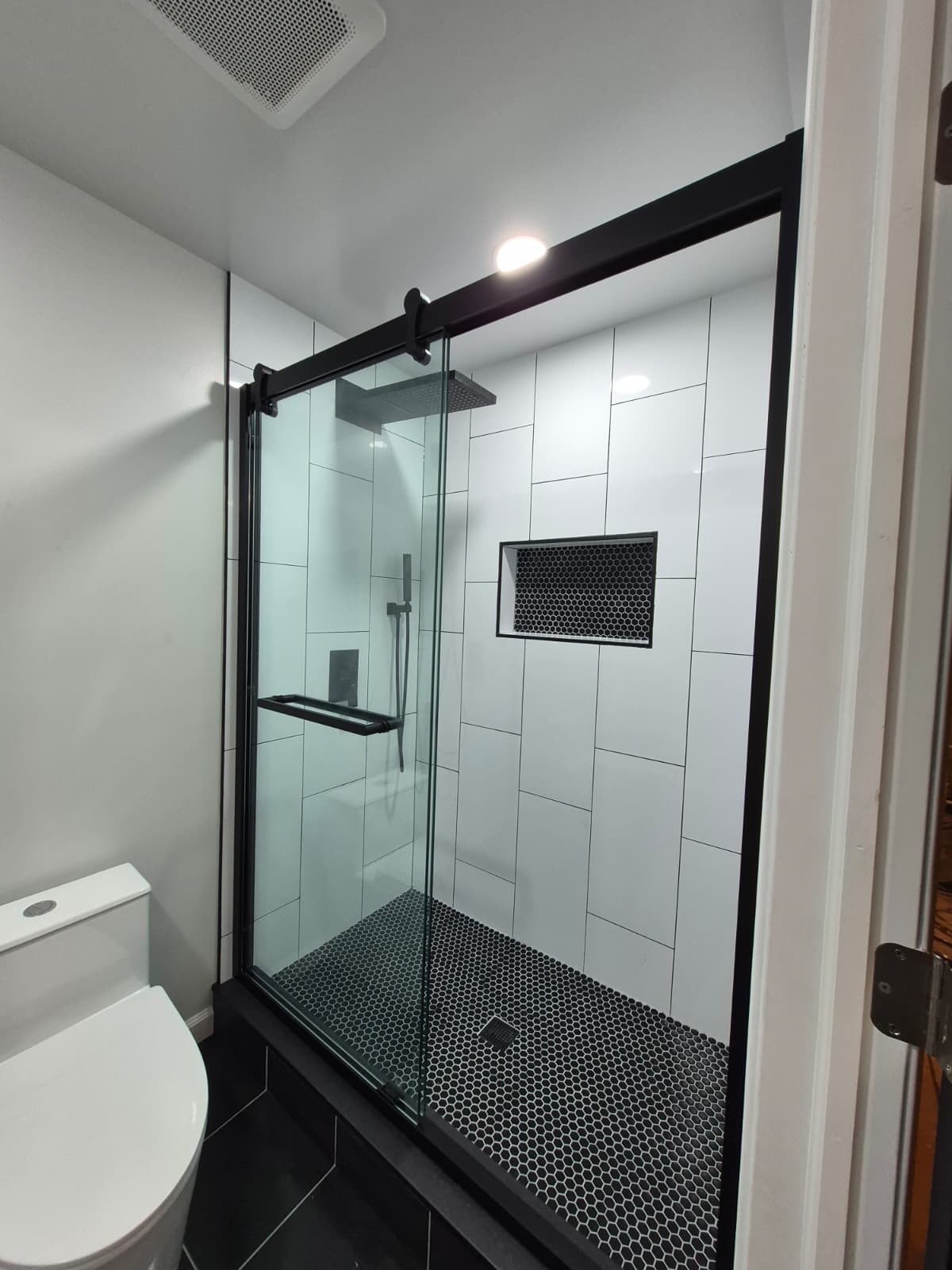 Basement bathroom after renovation — finished tile and fixtures