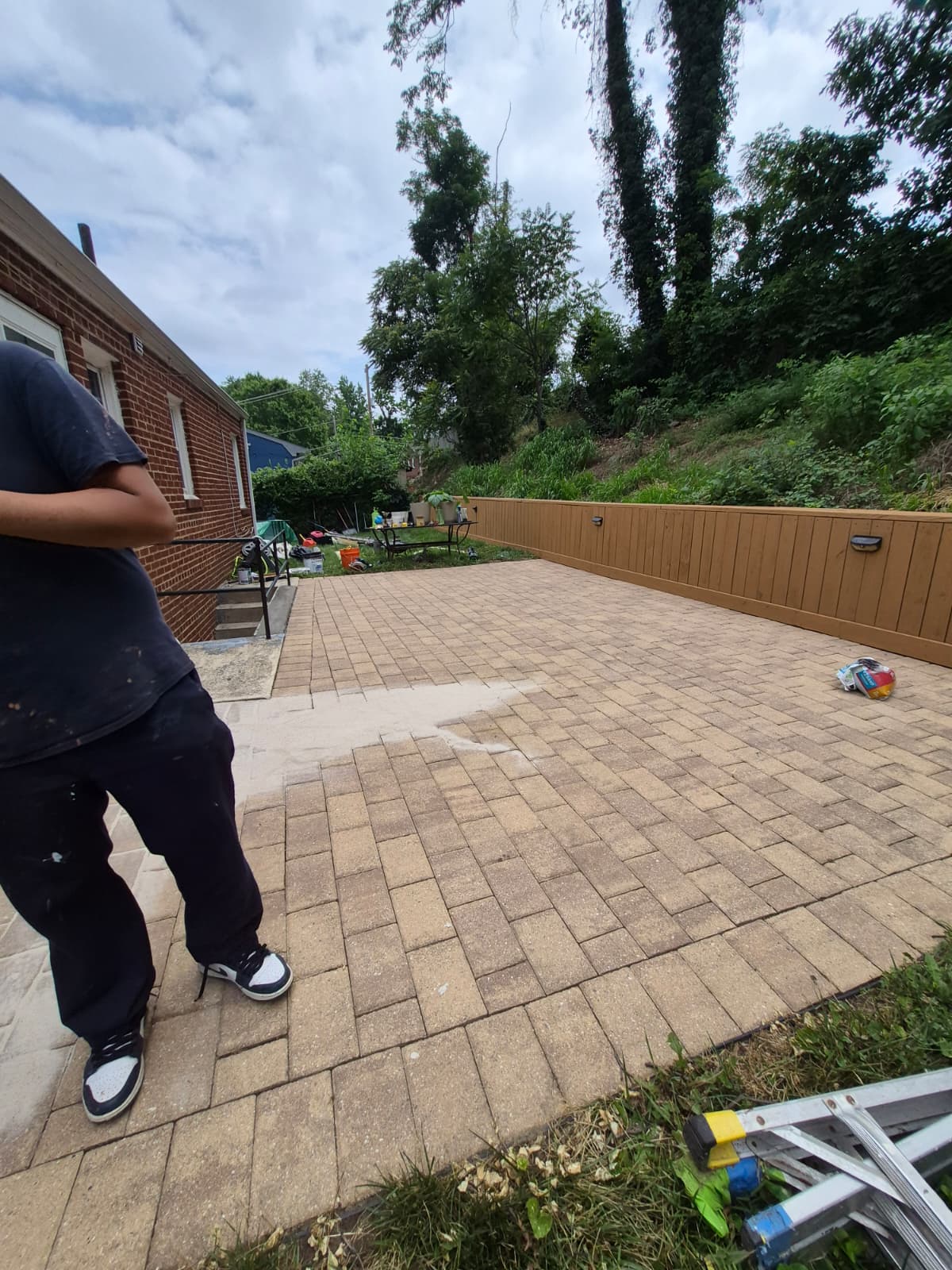 Backyard patio after renovation — new pavers and fence