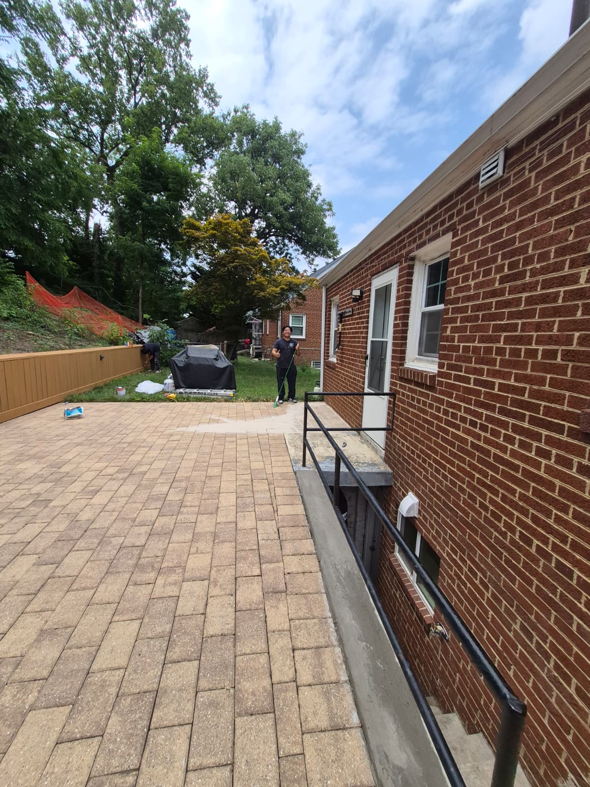 Backyard patio after renovation — new pavers and fence