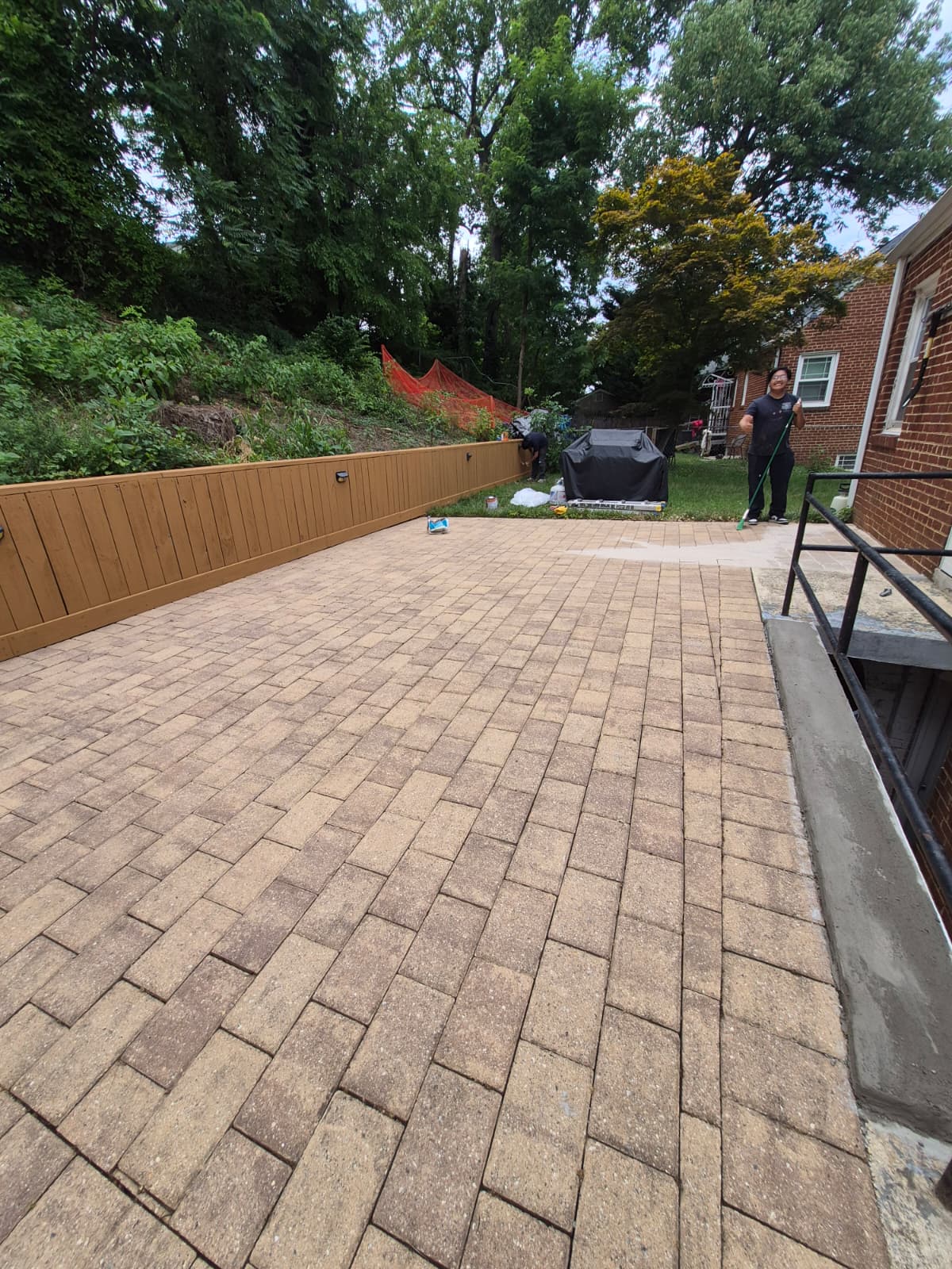 Backyard patio after renovation — new pavers and fence