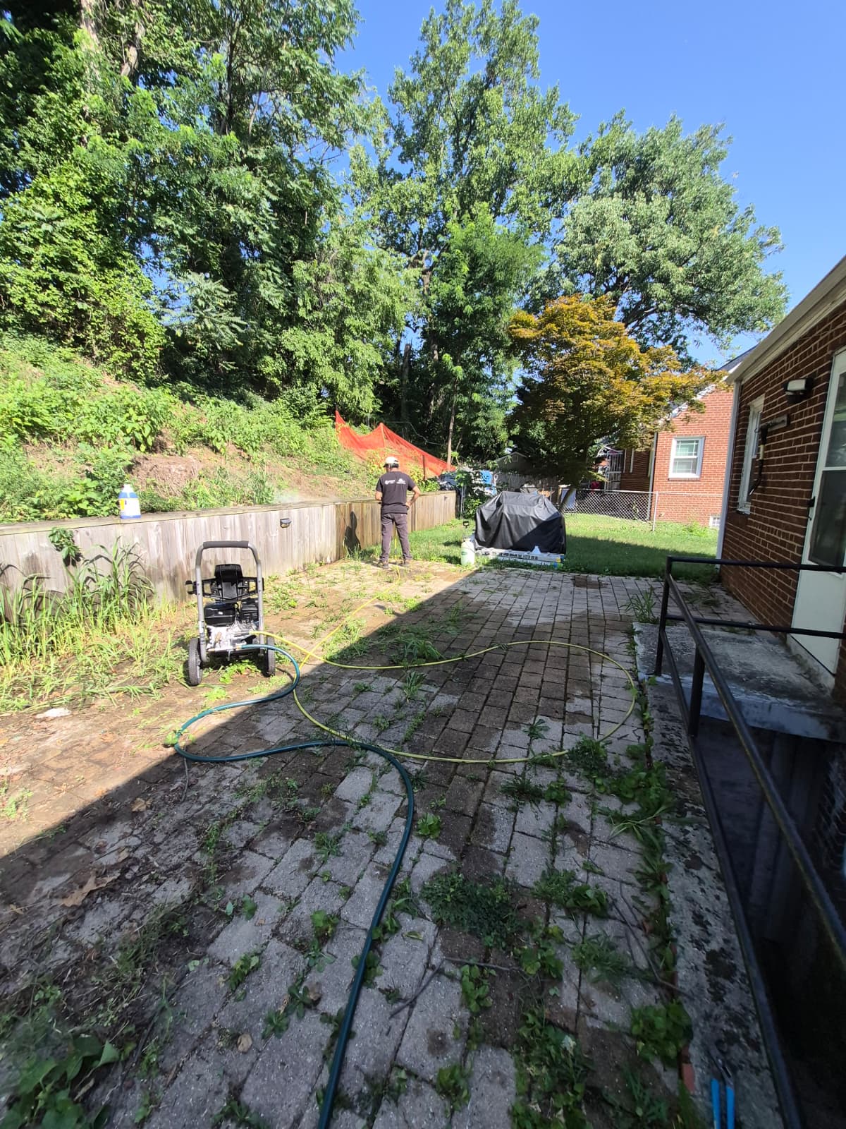 Backyard patio before renovation — old pavers and fence