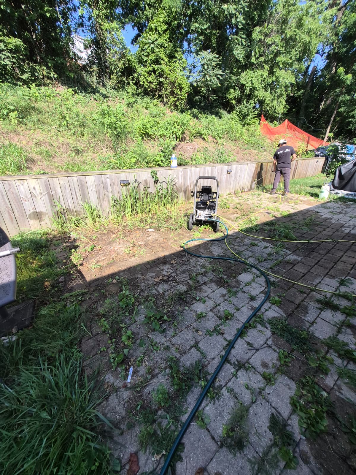 Backyard patio before renovation — old pavers and fence