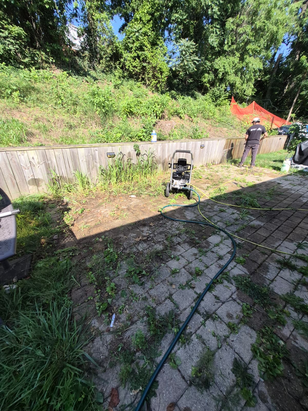 Backyard patio before renovation — old pavers and fence